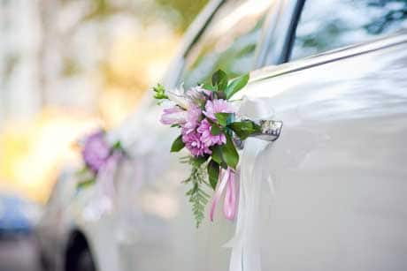 white limousine decorated with pink flowers